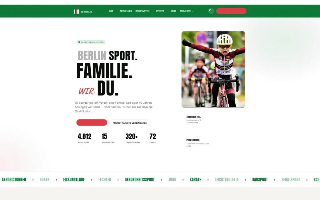 Junge Radsportlerin in Trikot jubelt mit Armen oben auf Rennrad beim Cycling-Wettkampf, Helm und Sonnenbrille, grüner Hintergrund